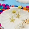 Coastal-inspired gold starfish and pearl long earrings, perfect for beachwear and tropical vacations.