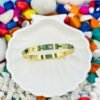 Gold bracelet featuring vibrant green colour rectangular shape diamonds – made from tarnish-free, hypoallergenic stainless steel