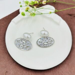 Oval drop earrings featuring dazzling diamonds and a radiant pearl