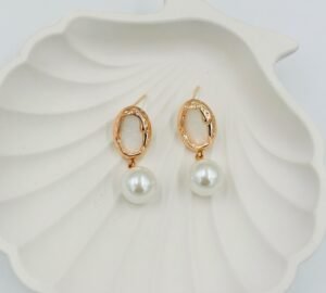 Elegant gold-toned drop earrings with a radiant pearl and white embellishment