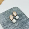 Elegant gold-toned drop earrings with a radiant pearl and white embellishment