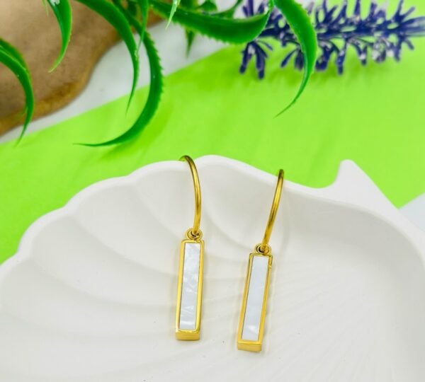 Square-shaped drop earrings in golden and white tones