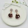 Contemporary-shaped earrings featuring colorful accents and diamonds