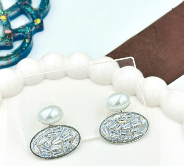 Oval drop earrings featuring dazzling diamonds and a radiant pearl