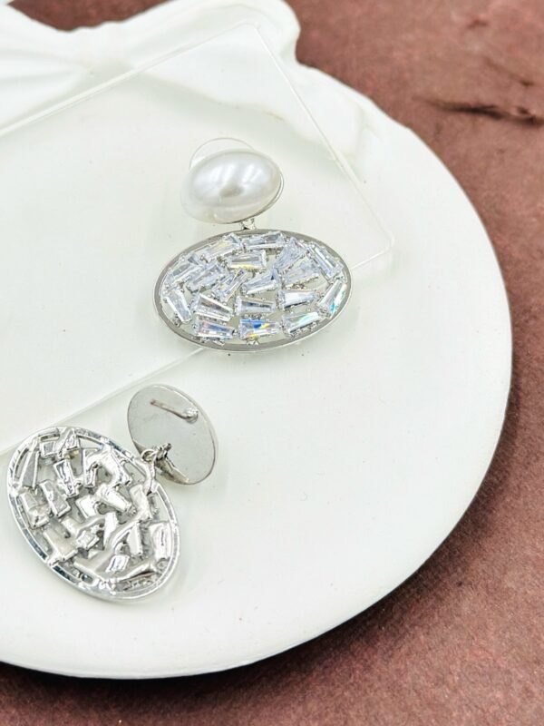 Oval drop earrings featuring dazzling diamonds and a radiant pearl