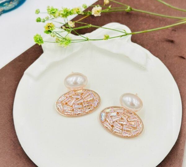 Oval drop earrings featuring dazzling diamonds and a radiant pearl