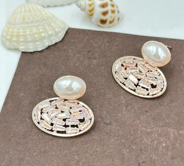 Oval drop earrings featuring dazzling diamonds and a radiant pearl
