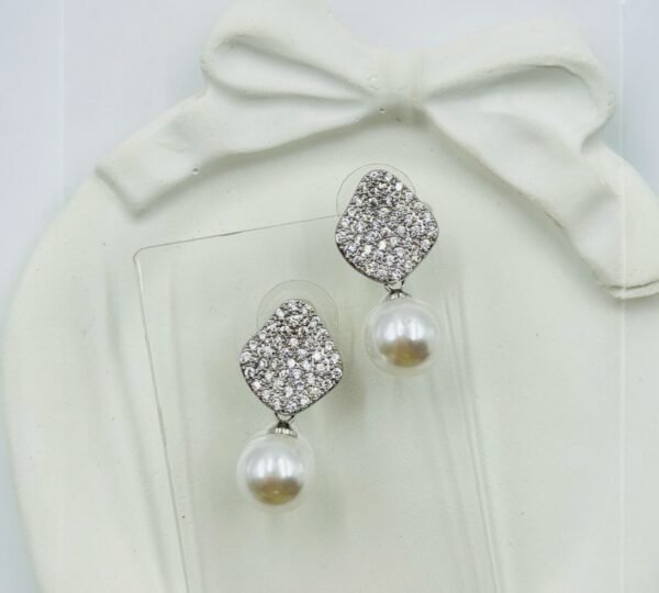Diamond-studded drop earrings with a radiant pearl